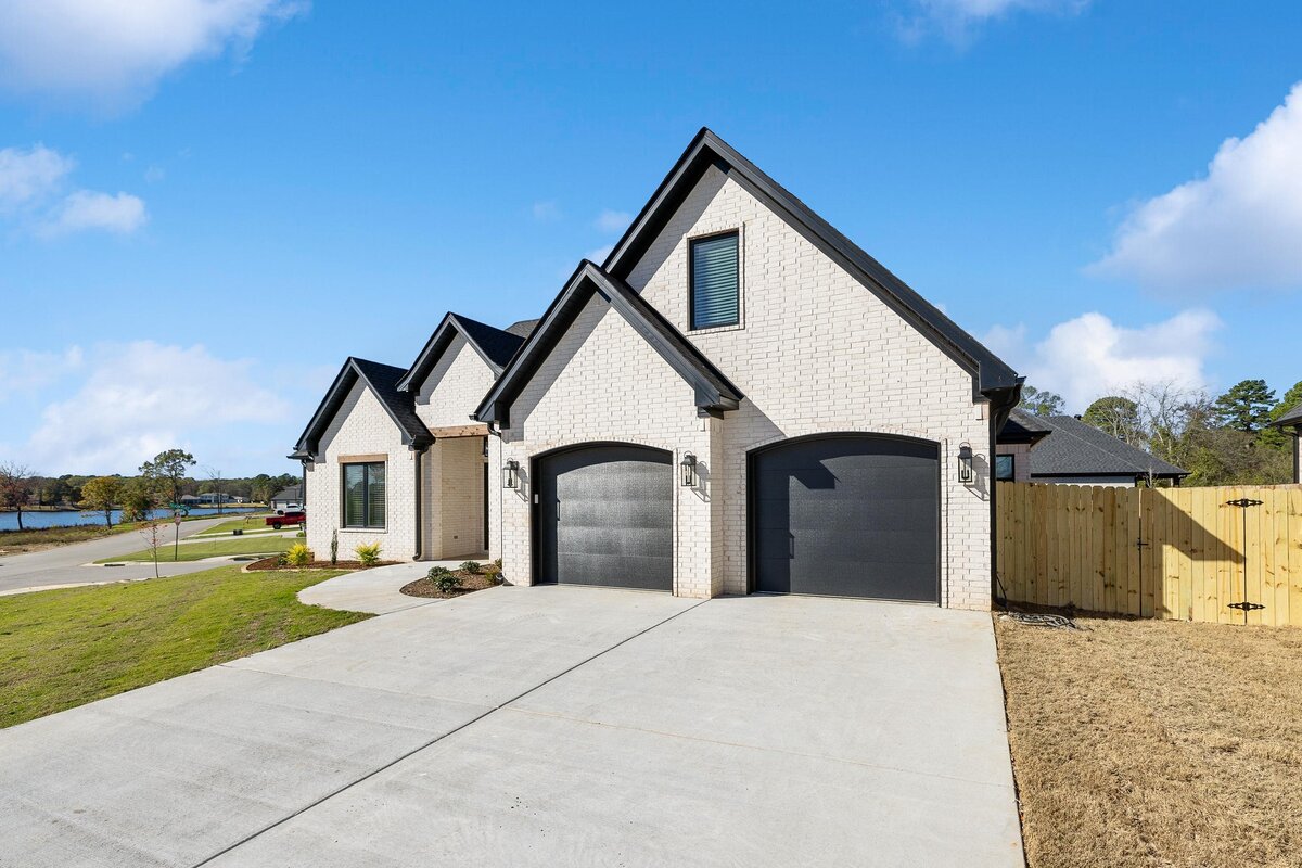 Front of 6011 Majestic Waters. White house with black trim and wood details.