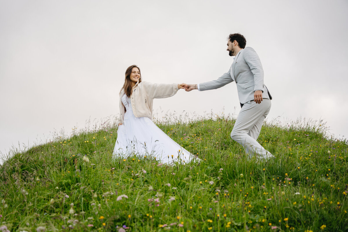 Couple holding hands in a flower field in Switzerland