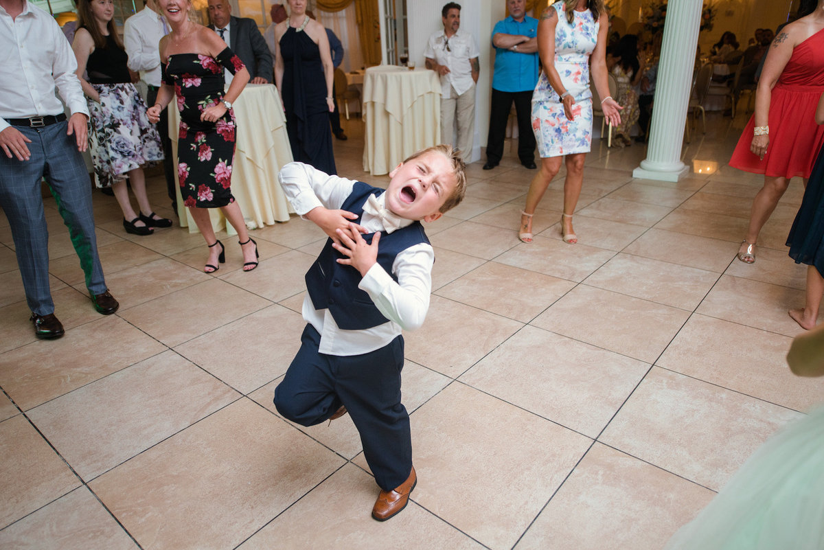photo of ring bearer dancing in the middle of the dance floor during wedding reception at Lombardi's on the Bay