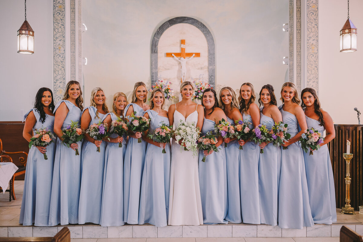 Bride and her bridesmaids with floral bouquets at Sacred Heart Church in Canton, Mississippi.
