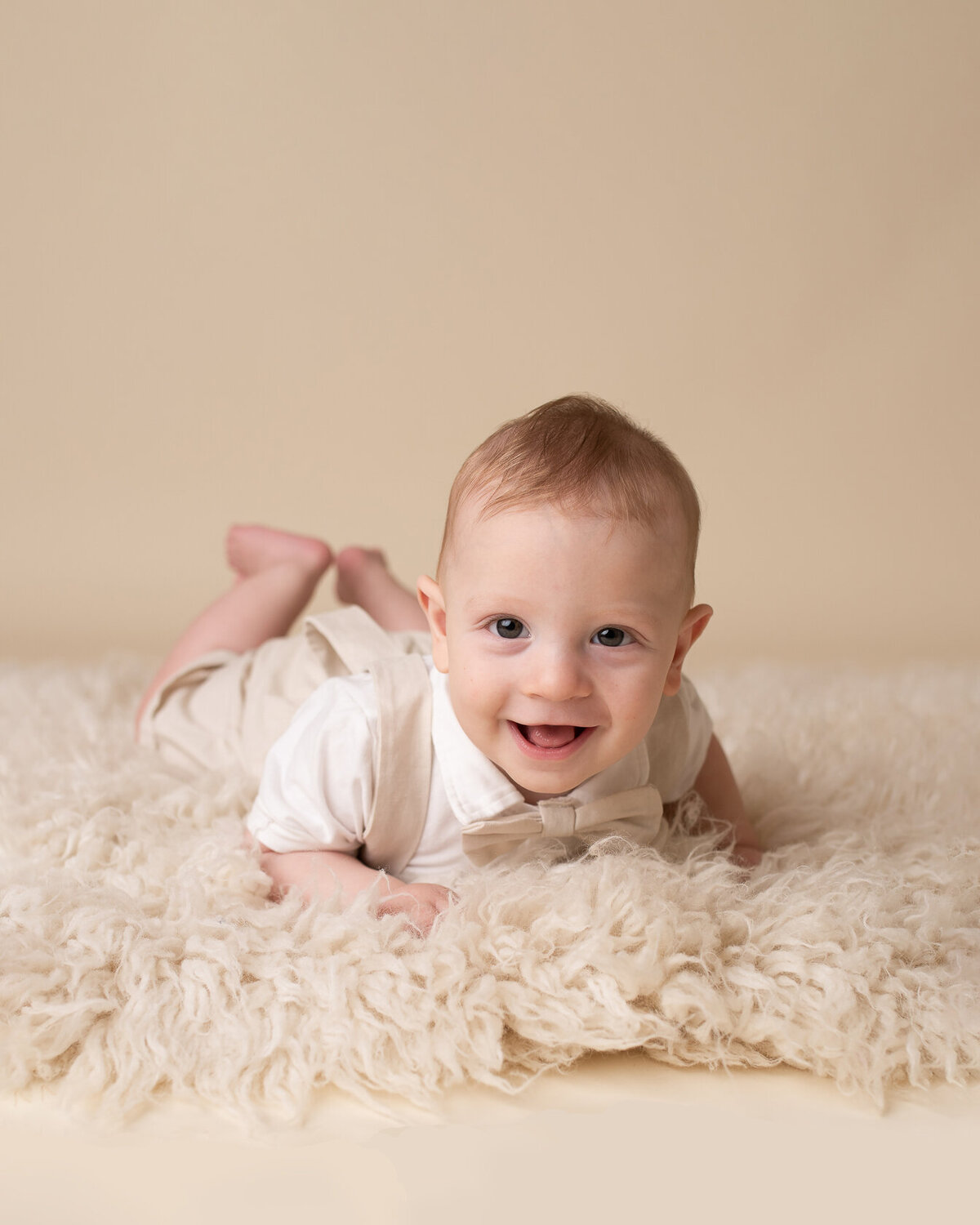 Cute smiling baby in cream furry background