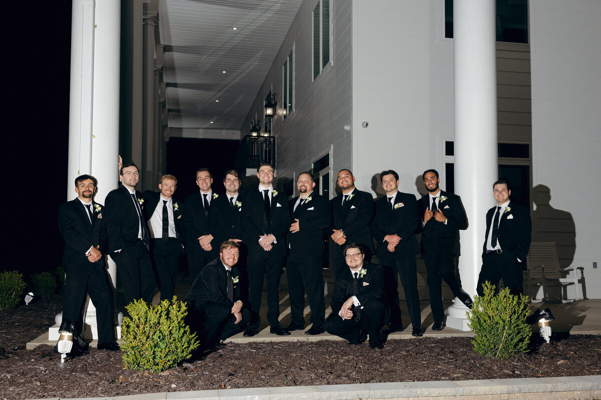 A wedding photo of the groom and his groomsmen in front of the wedding venue Legacy Acres