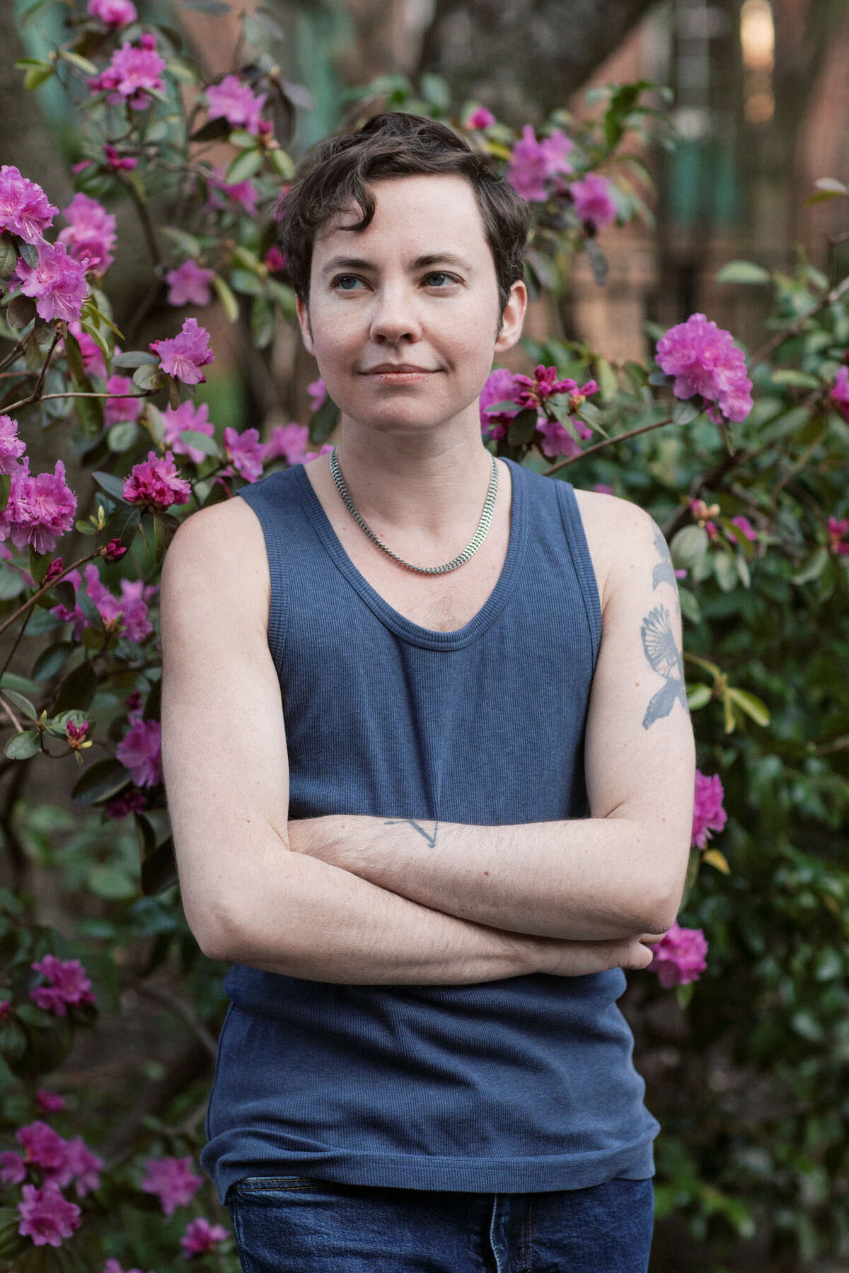 portrait of writer james frankie thomas in a garden surrounded by purple flowers