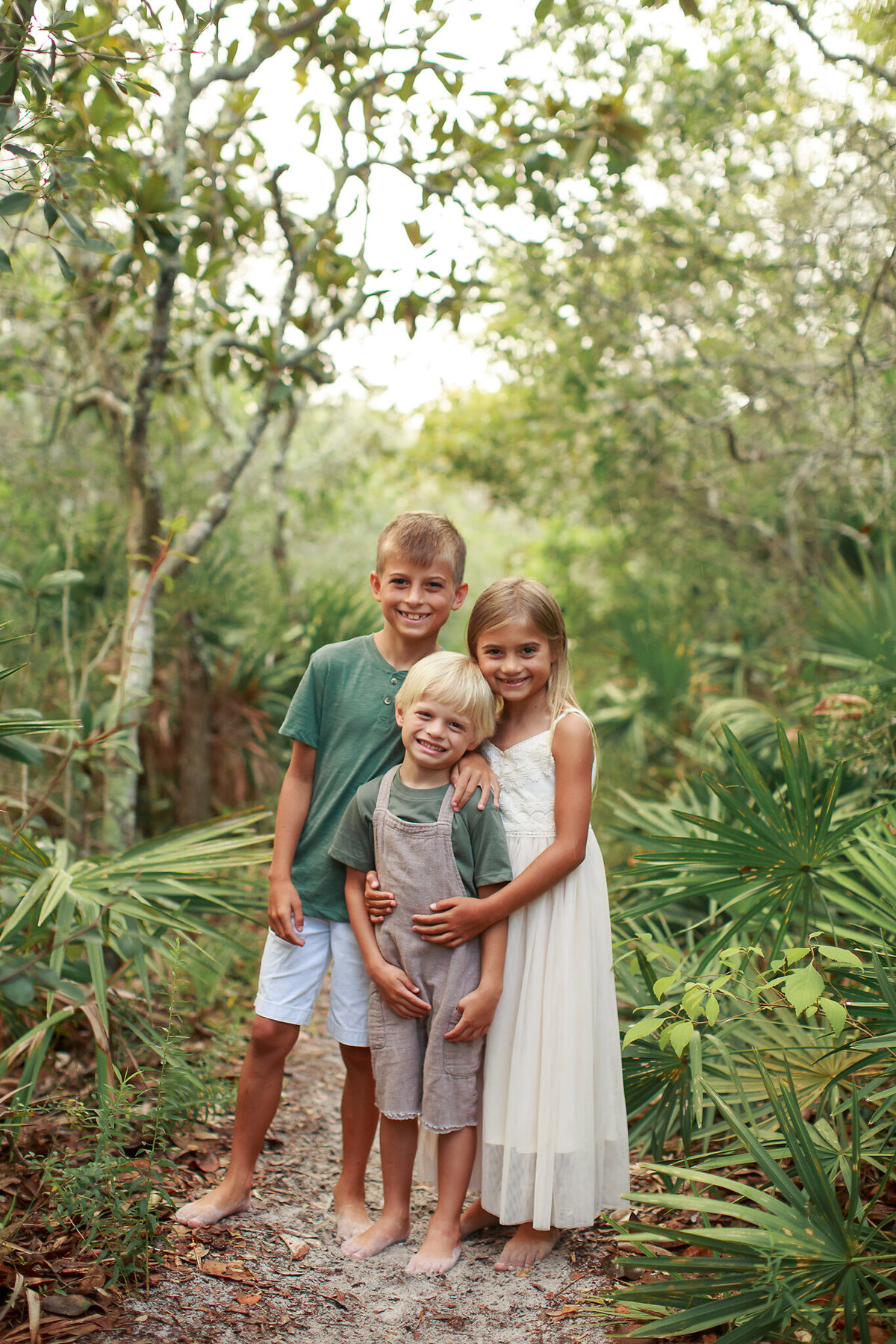 siblings together on the trail at grayton beach state park, florida for a sunrise session.