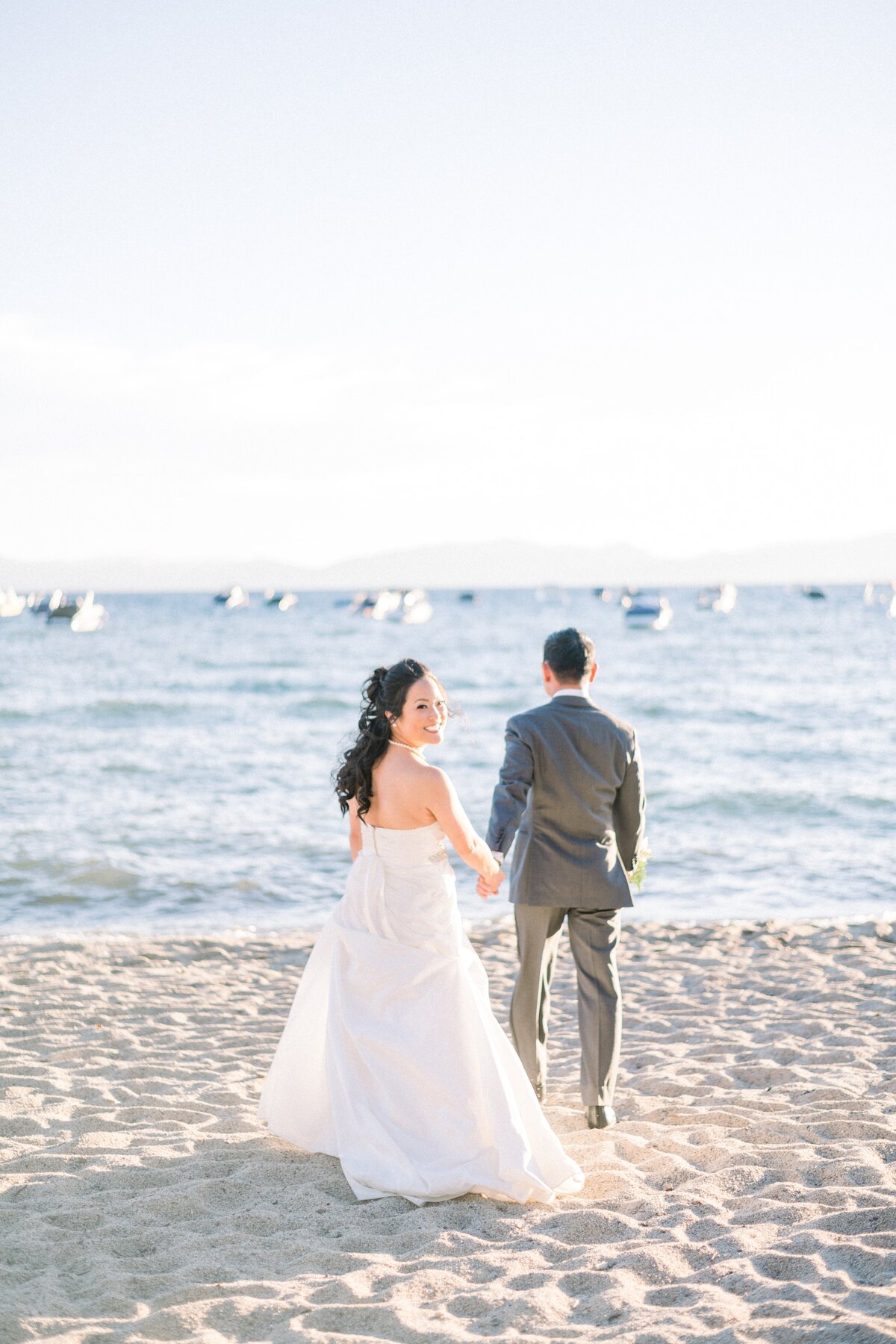 bride and groom walking on tahoe beach