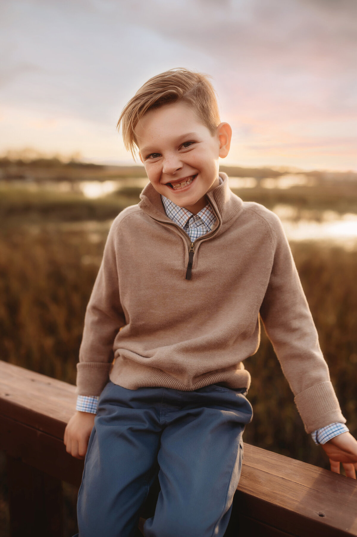 Little boy sits on a dock during Family Photos in Charleston.