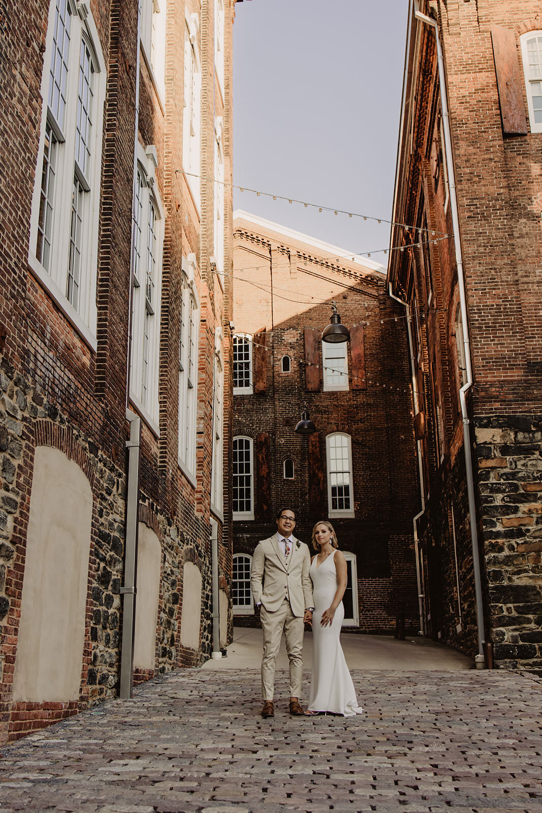 Newlyweds standing in an alley between buildings 
