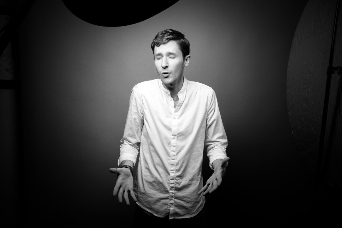 Candid editorial-style studio portrait of an actor mid-story, captured with emotive expression.