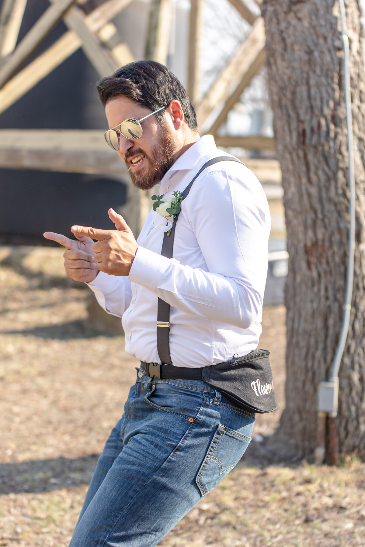flower man dances down aisle in sunglasses and suspenders with fanny pack in Boerne Texas