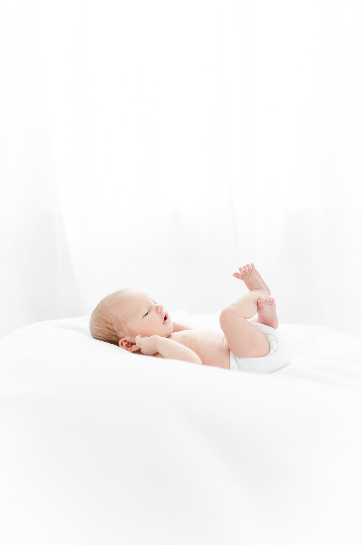 baby on a white bean bag In Kristie Lloyd’s Nashville newborn photographer studio