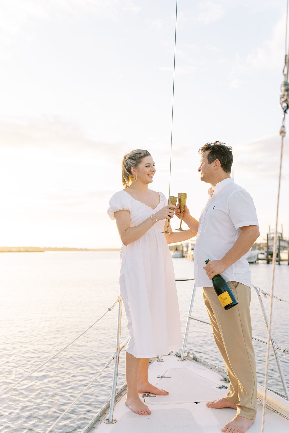 Engaged couple enjoying champagne on a sailboat