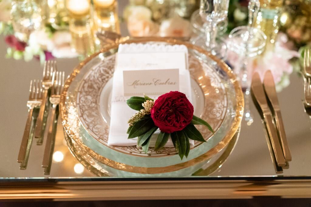 A flower laying on a table setting at a wedding reception