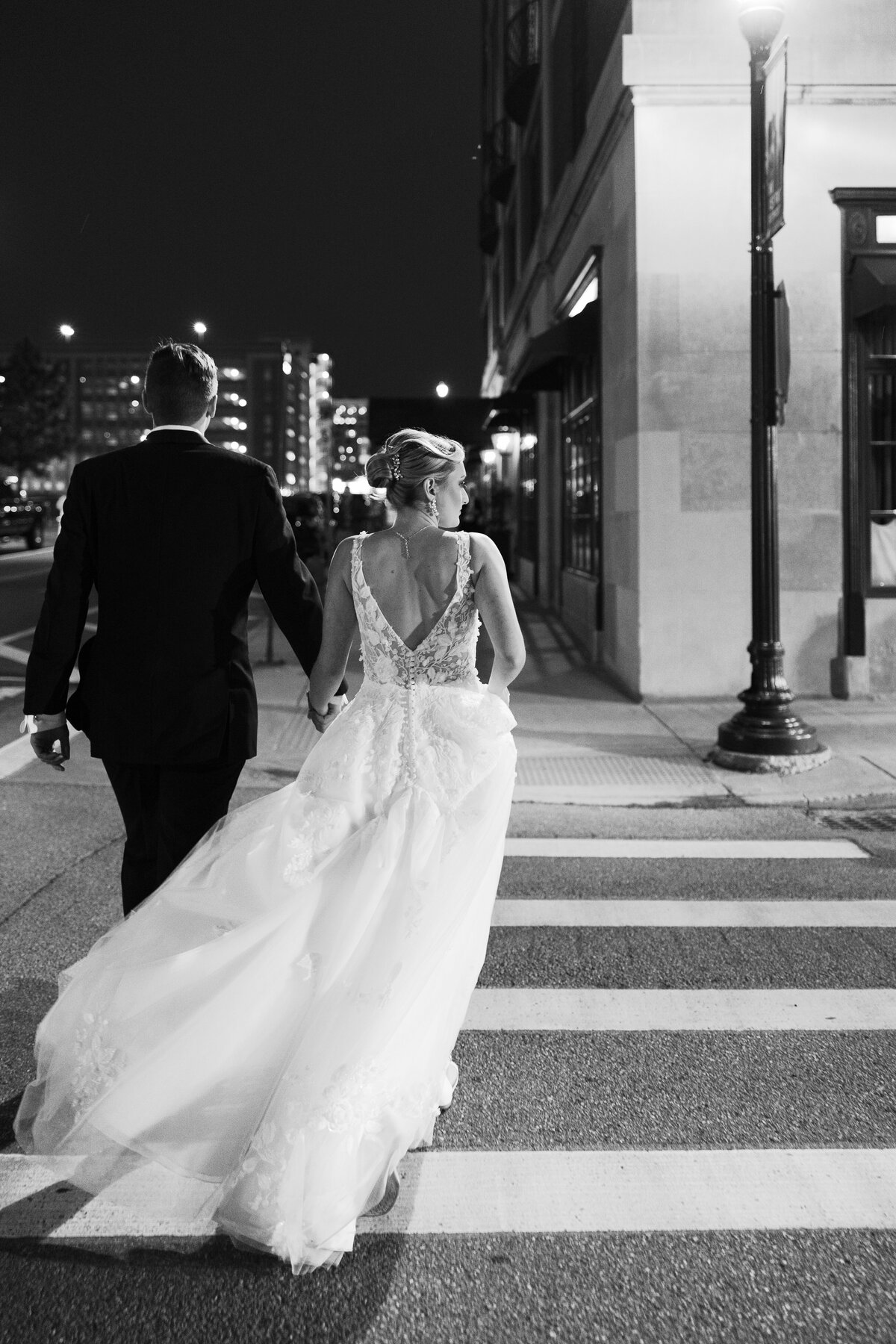 Bride and groom crossing the street at night near the colony club in detroit mi