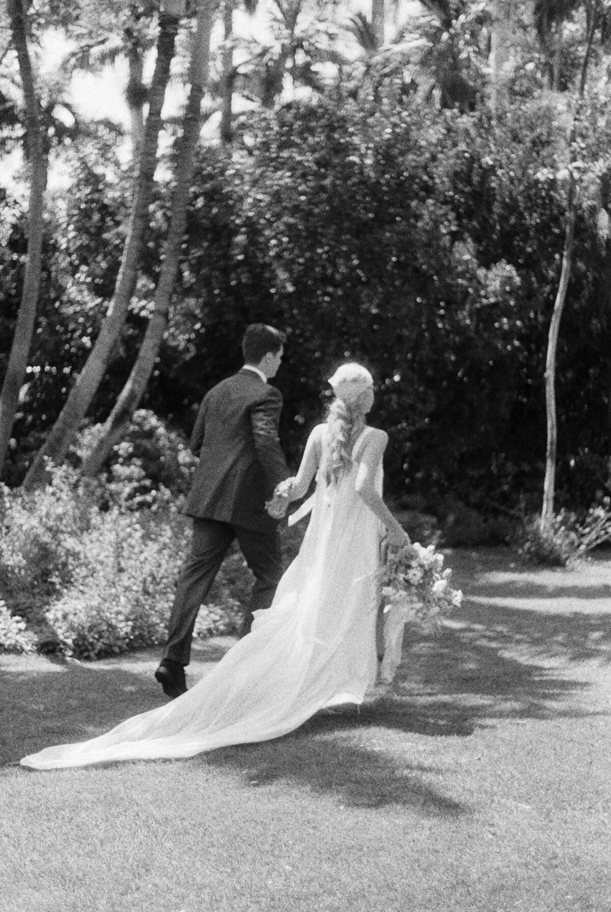 A couple walks away after ceremony in black and white.