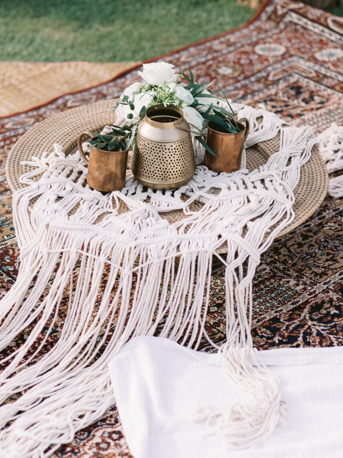 A native wood with knitted white table cloth, white flowers, and bronze cups at Khayangan Estate, Indonesia. Image by Jenny Fu Studio