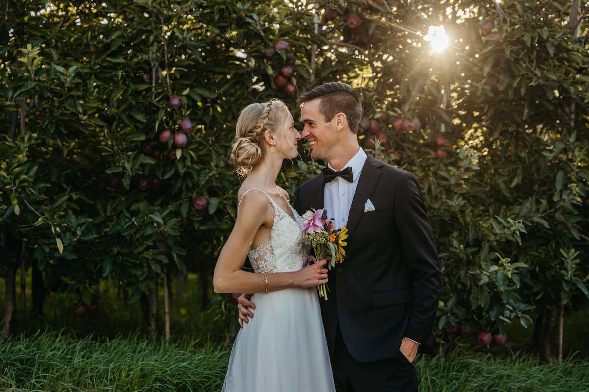 Bride and groom kissing in garden during golden hour
