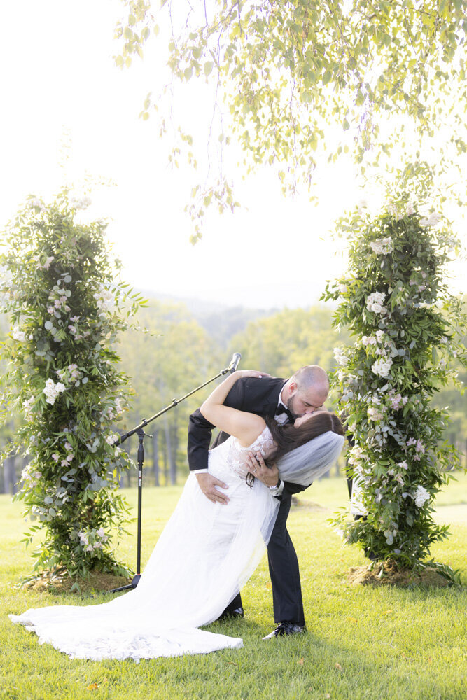 bride and groom share first kiss as husband and wife - candlelight farms inn wedding