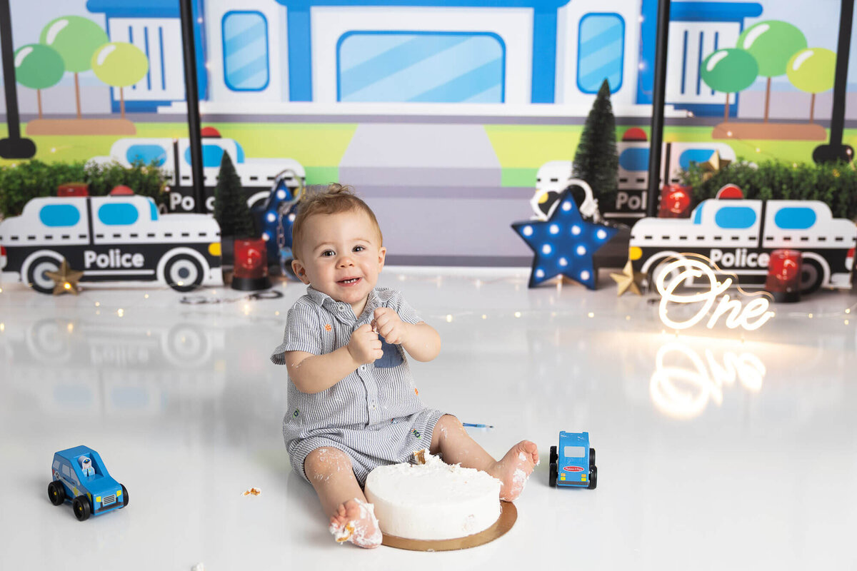 Baby boy with police themed cake smash session near Seguin