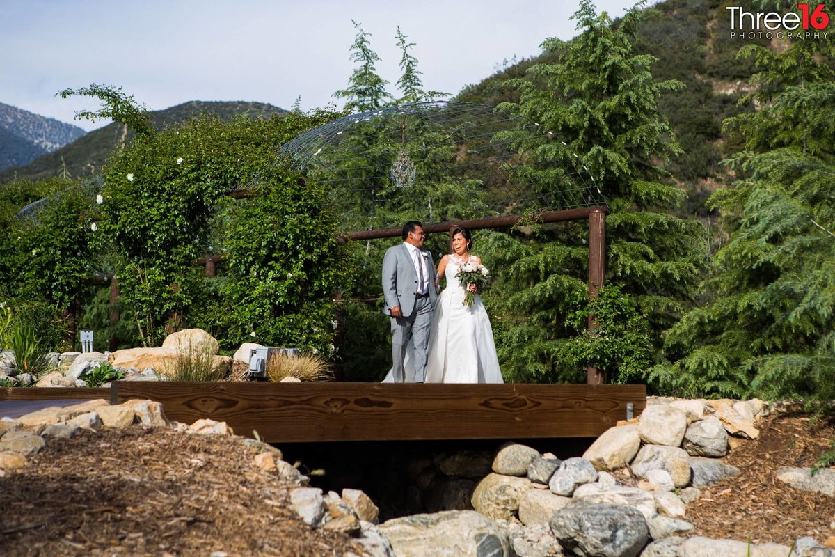 Bride and her father standing on a bridge before he escorts her down to her Groom