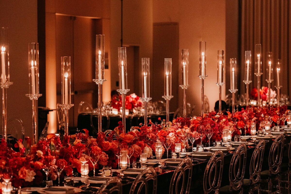 long wedding reception dinner tables with clear crystal candelabras and red flowers by Philadelphia wedding florist Sebesta Design