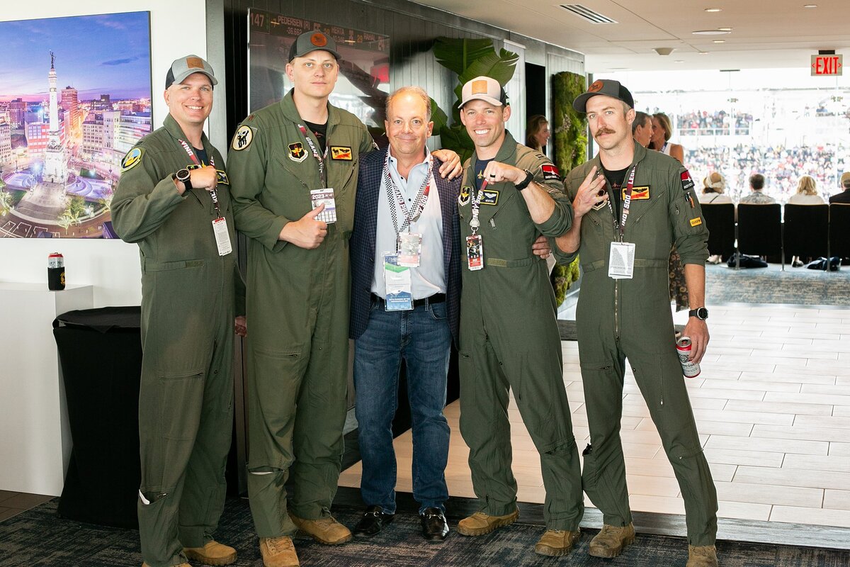 a-group-of-military-personnel-in-uniform-posing-with-a-business-leader-at-an-armed-forces-day-event-in-indianapolis-at-ims