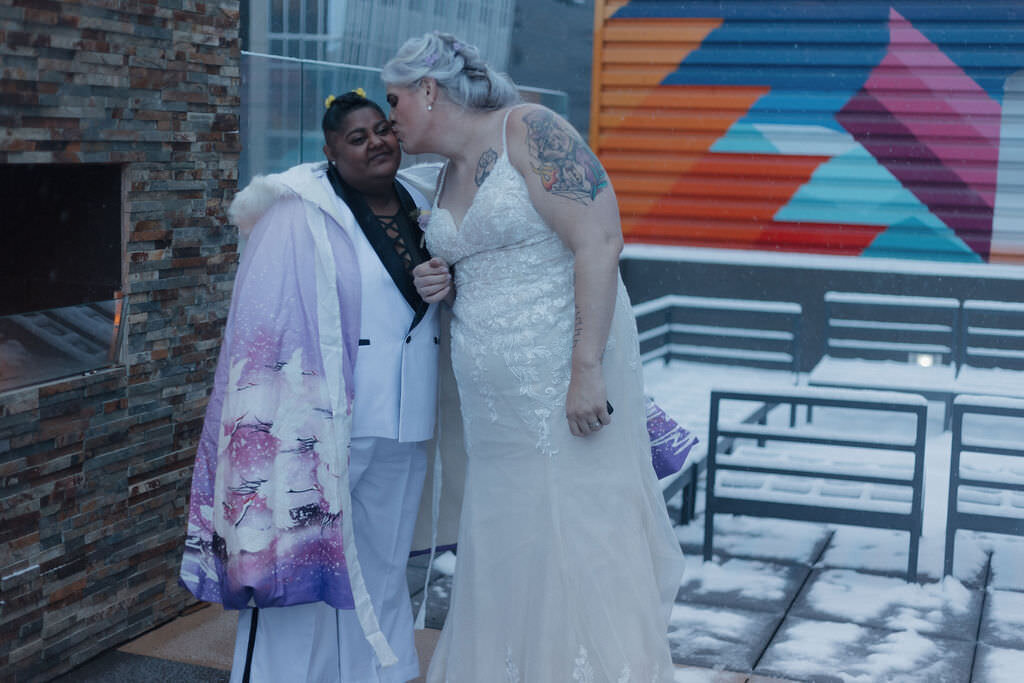 A person kissing their partner's cheek.