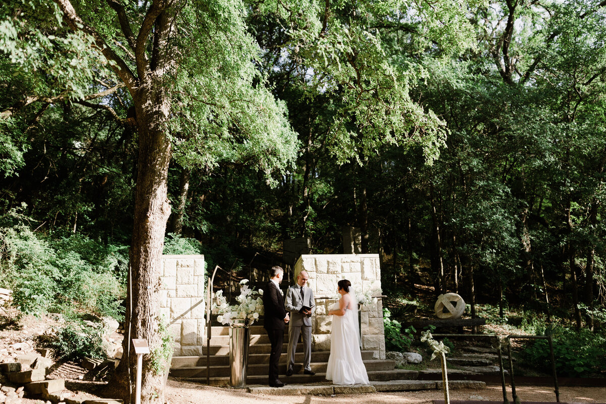 Bride and groom at wedding ceremony at Umlauf Sculpture Garden, Austin