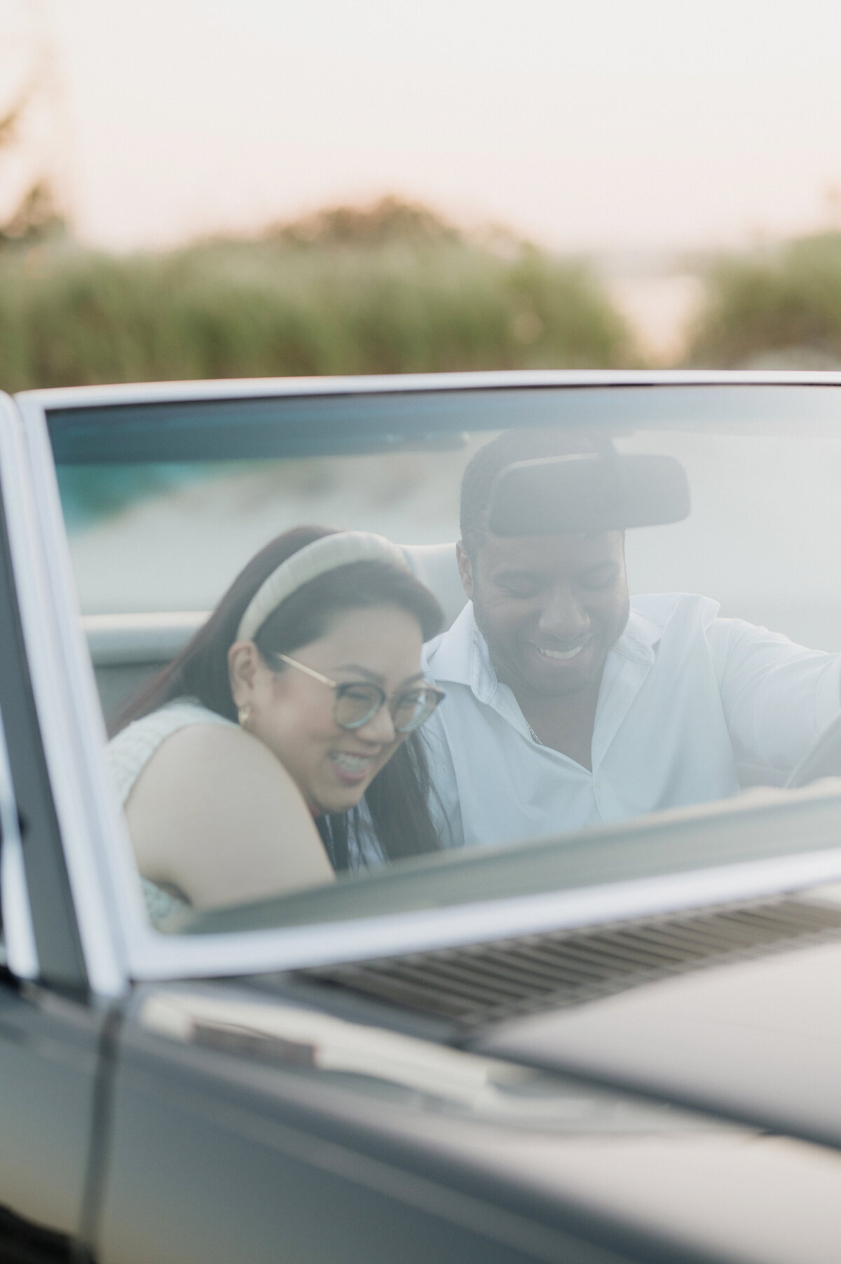 costal engagement session with vintage black mercedes benz  and a multicultural couple. asian women and black man in massachusetts