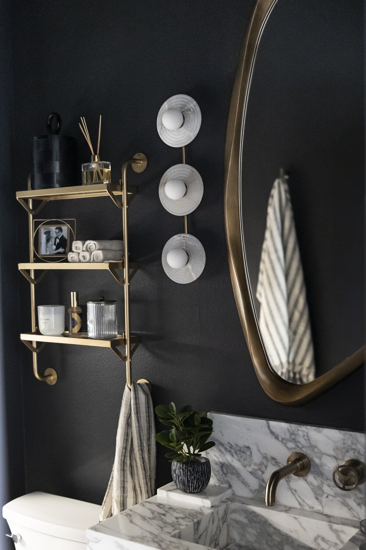 dewine design interiors moody guest bathroom with black painted walls and gold accents
