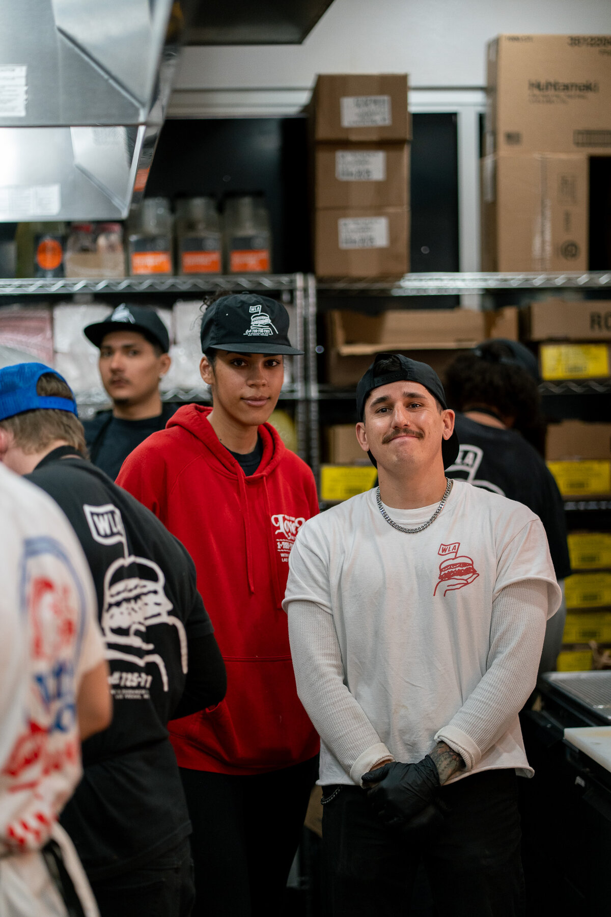 With Love, Always team members working in the kitchen at the Las Vegas location, wearing branded uniforms and apparel