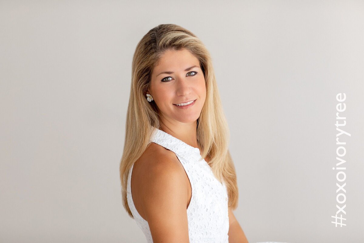 a clean headshot of a woman with blonde hair wearing white