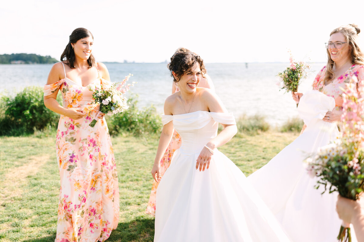 Bride in direct sunlight with her bridesmaids in documentary photography style as captured by Rachael Reid Photography