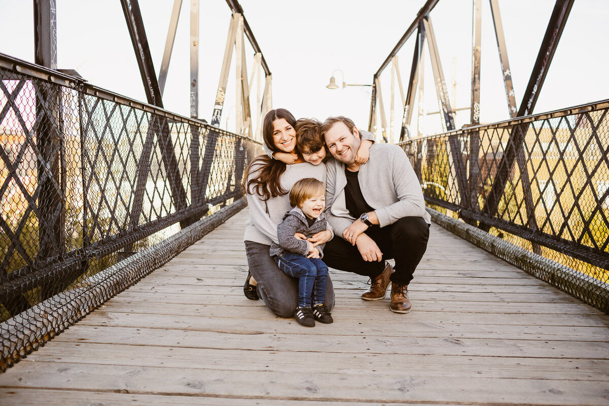 family of 4 smiling on Toronto Wallace Pedestrian Bridge