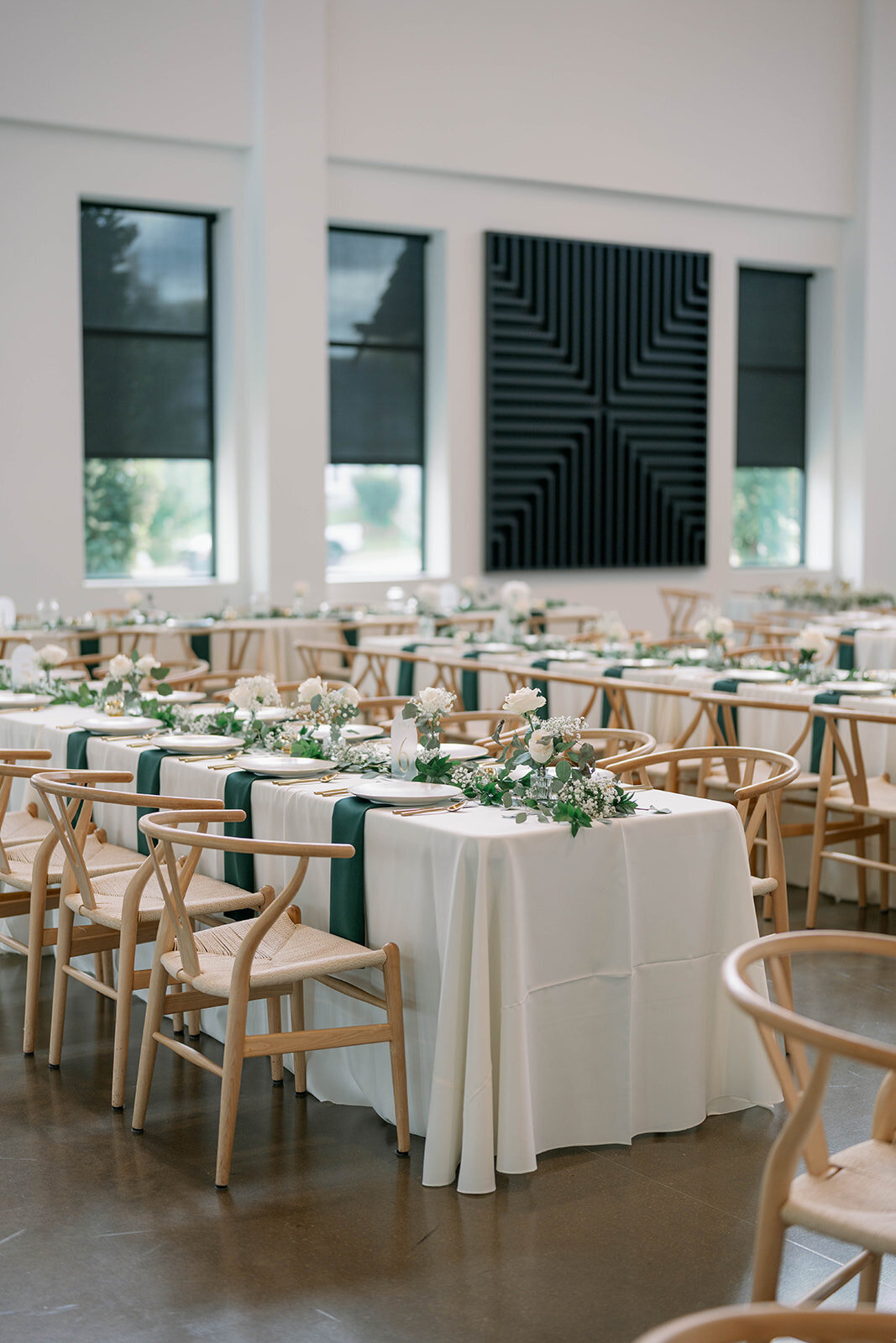 Close-up of the wedding table scape featuring candles, greenery, glassware and neutral linens at Leona Road in Grand Rapids, Michigan.