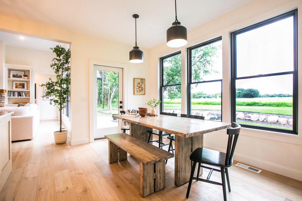 Open kitchen with white cabinets, large island, and quartz countertops in an Otsego custom home