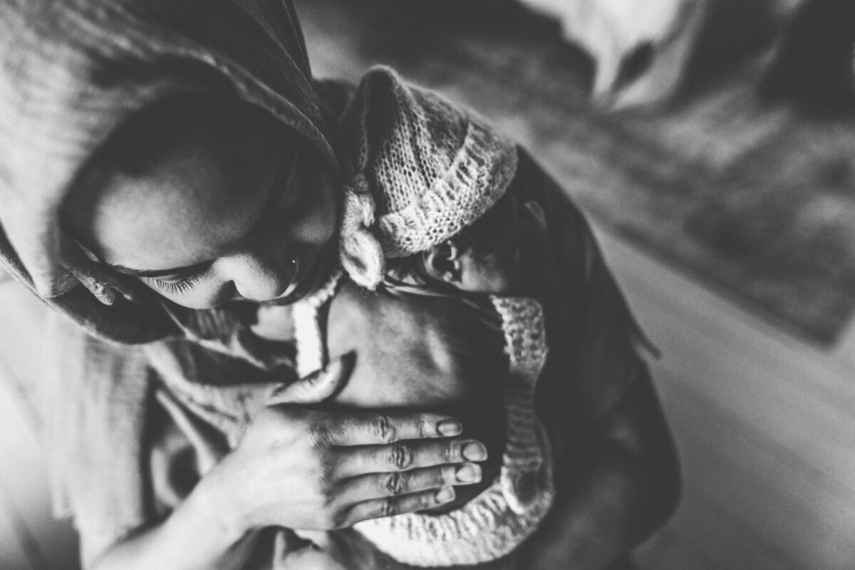 Newborn photography of mother holding newborn babe.