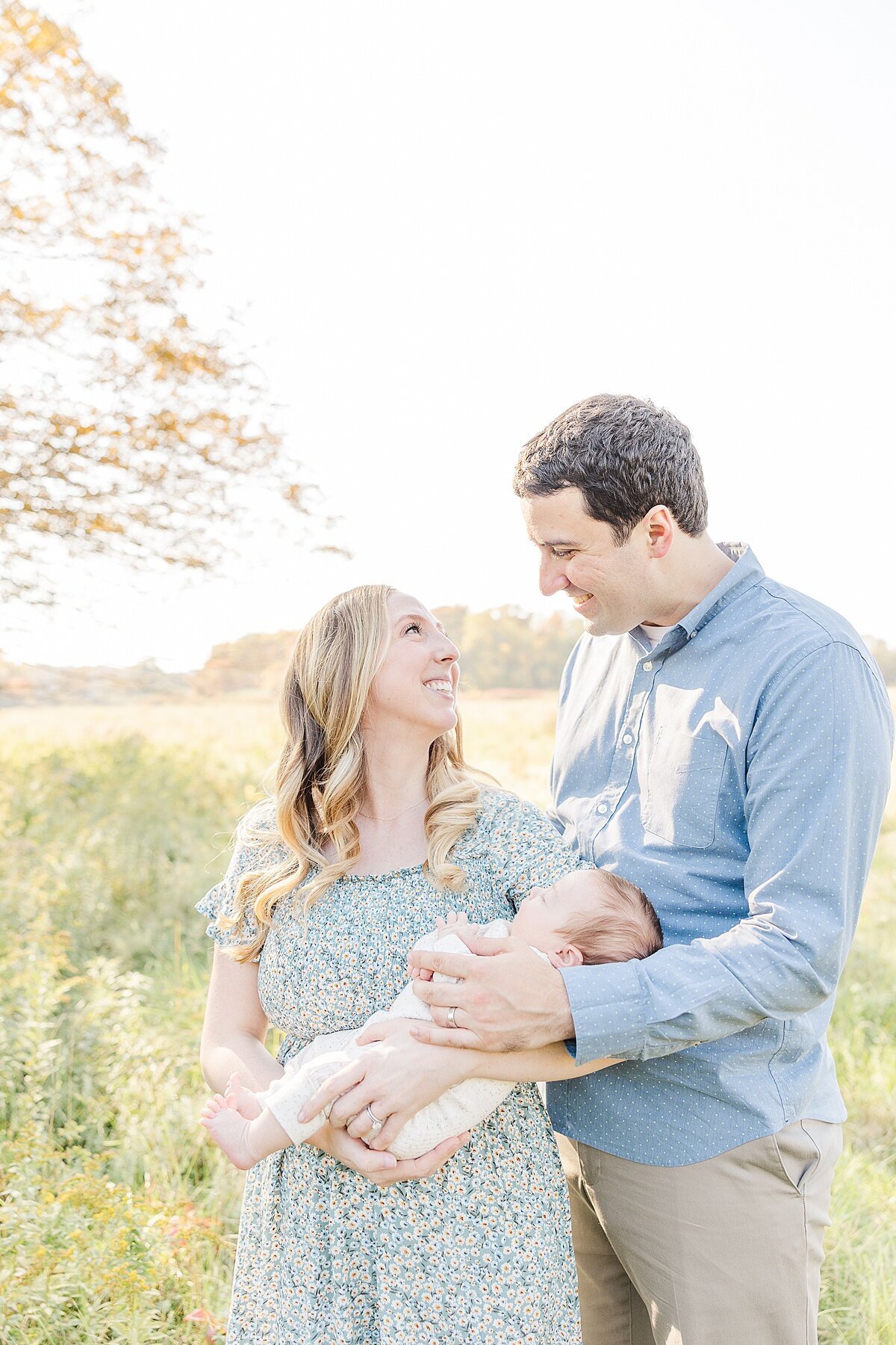 parents hold baby during outdoor newborn photo session in Natick Massachusetts with Sara Sniderman Photography