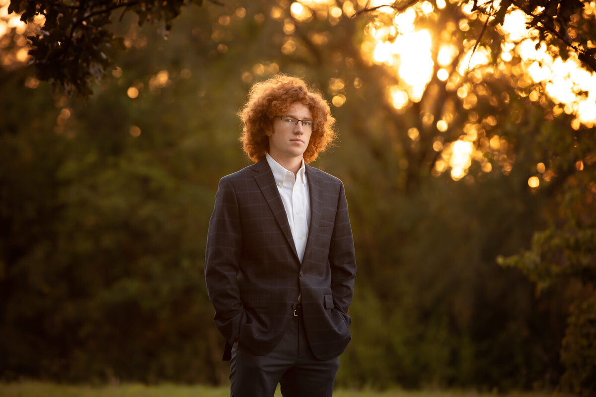 senior-boy-in-a-suit-at-a-park-in-arlington-tx-with-red-afro