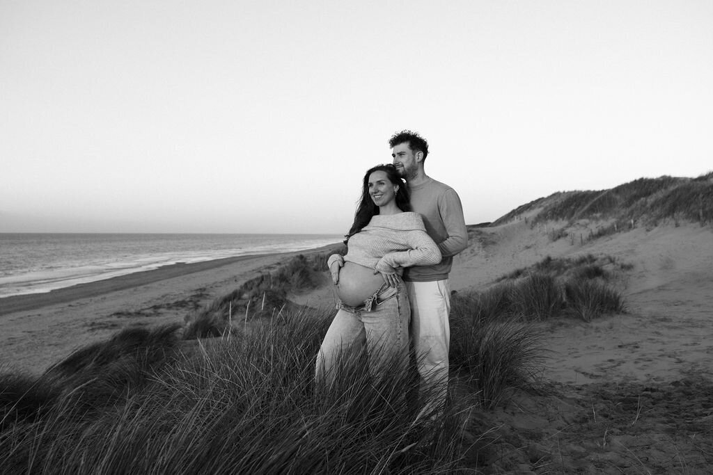 Zwanger koppel tijdens zwangerschapsshoot in de duinen