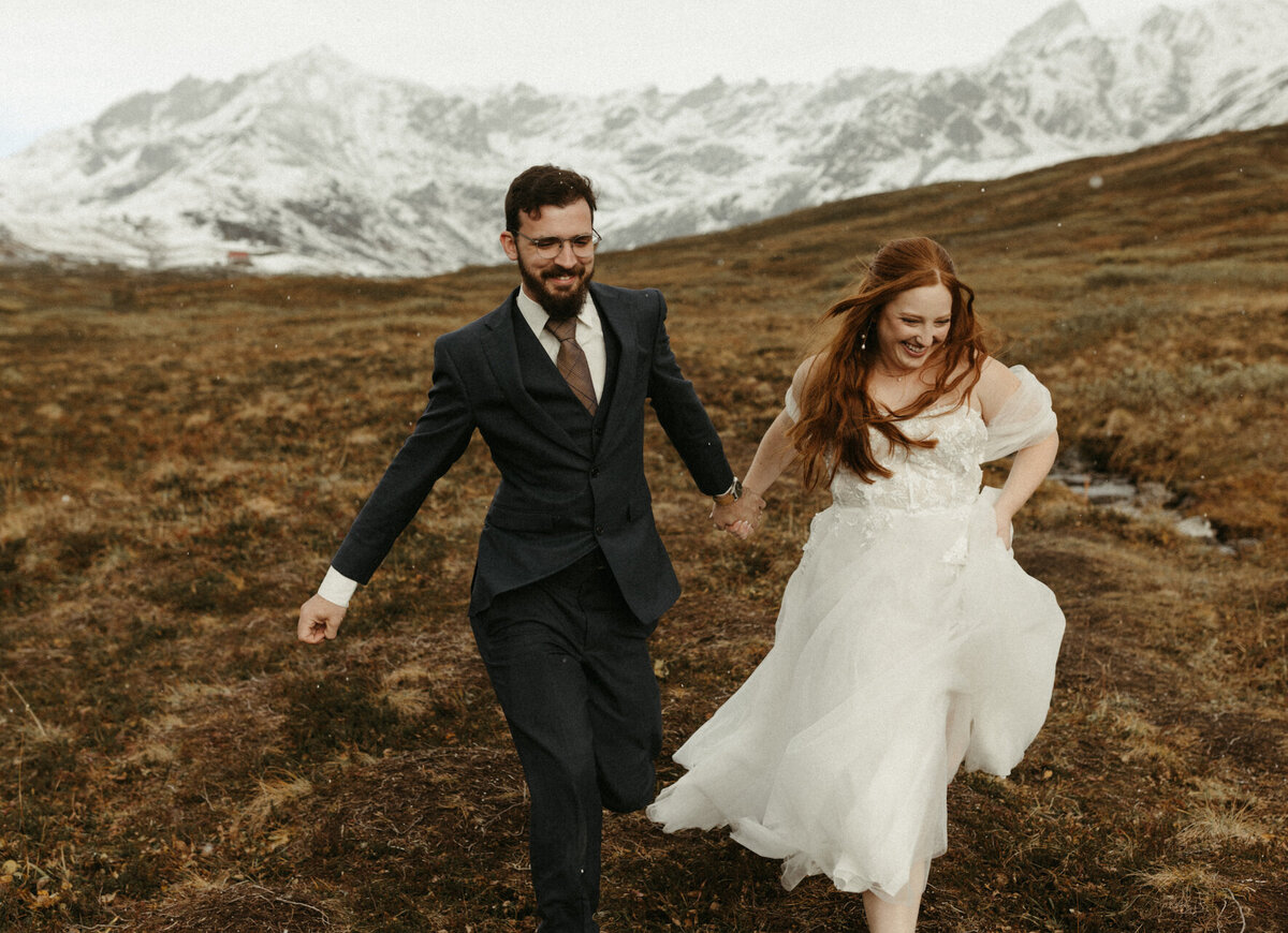 Couple running while holding hands.