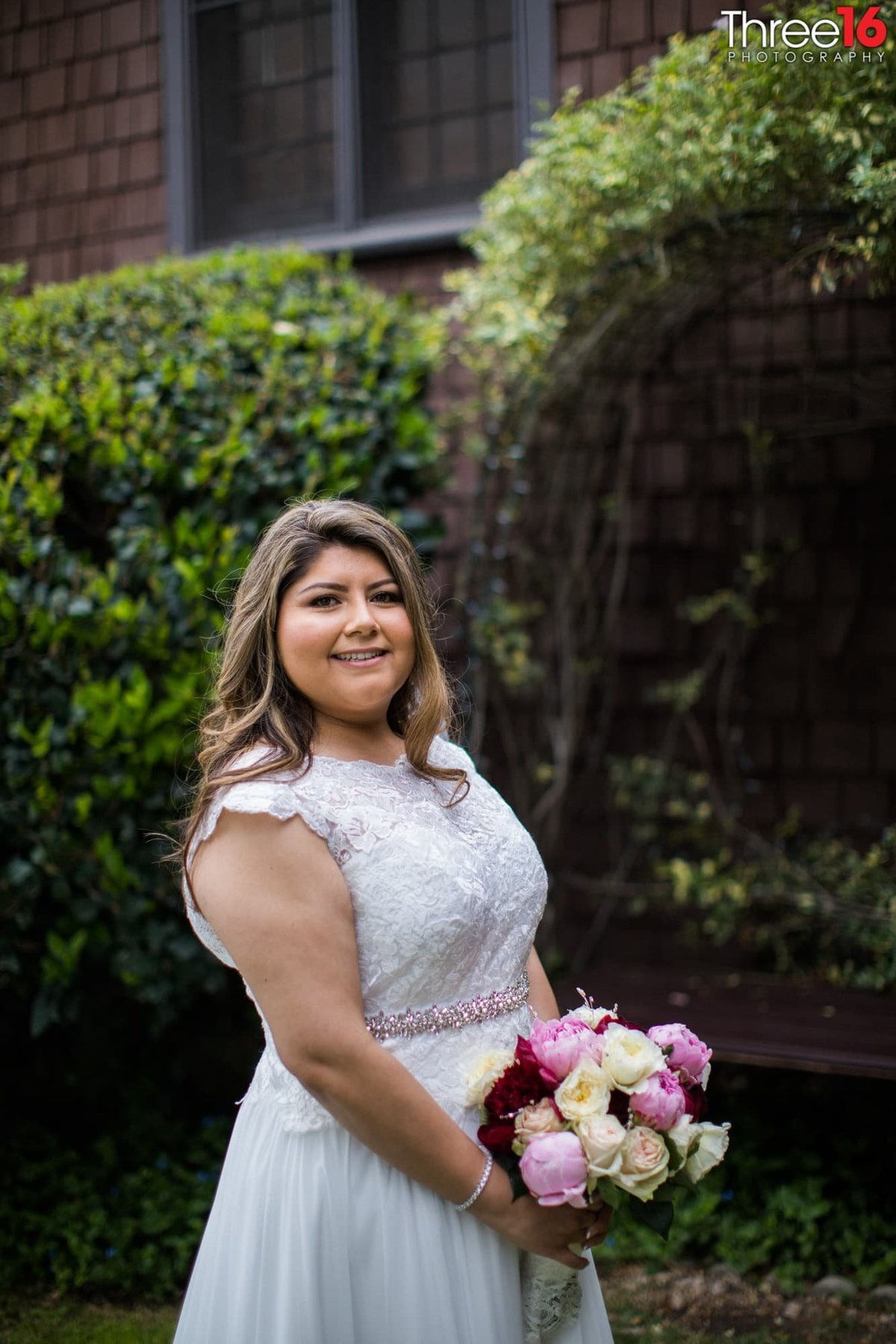 Bride poses for the wedding photographer with her bouquet