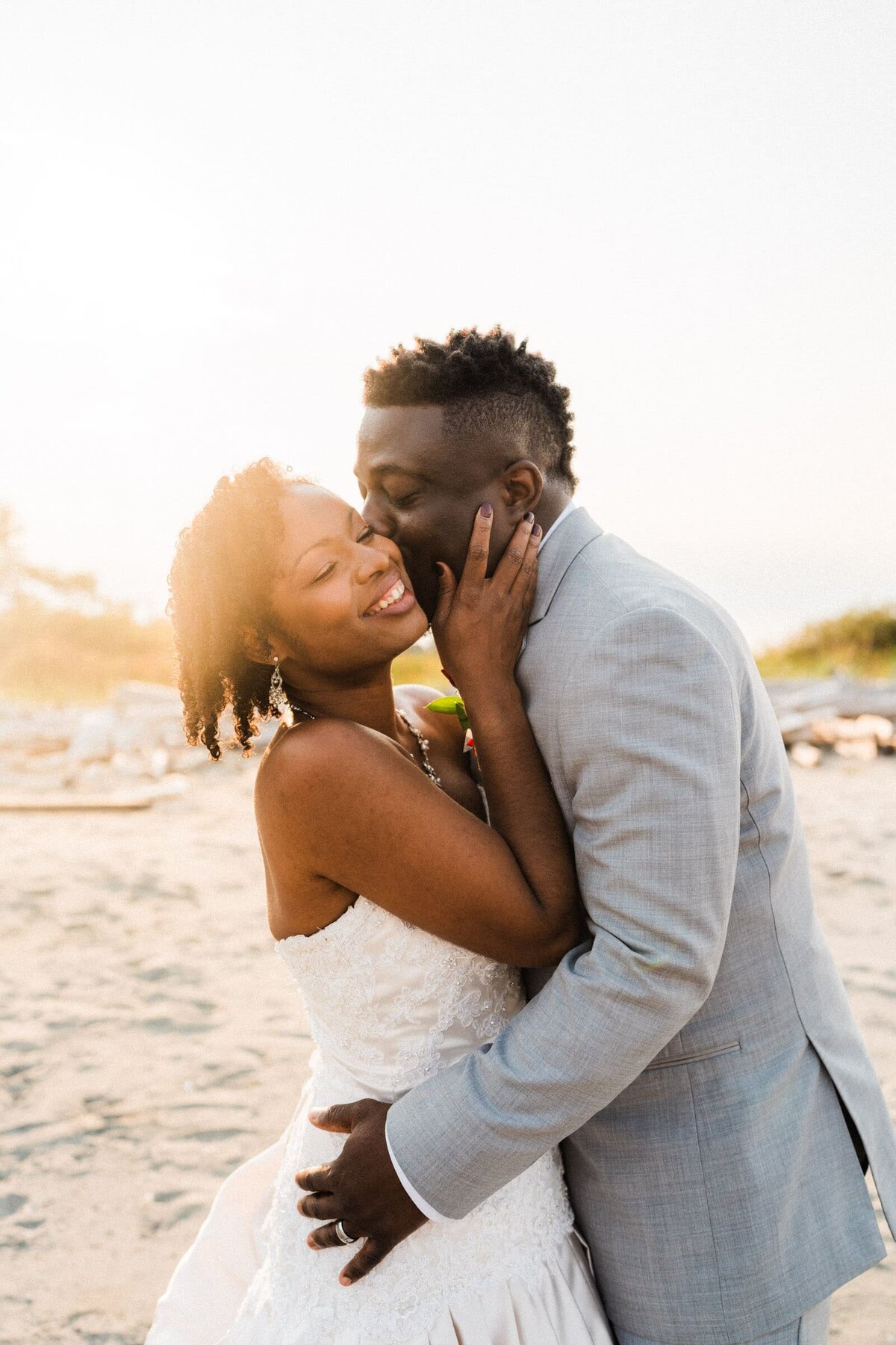 african american couple giving cheek kisses on a  beach in washington.