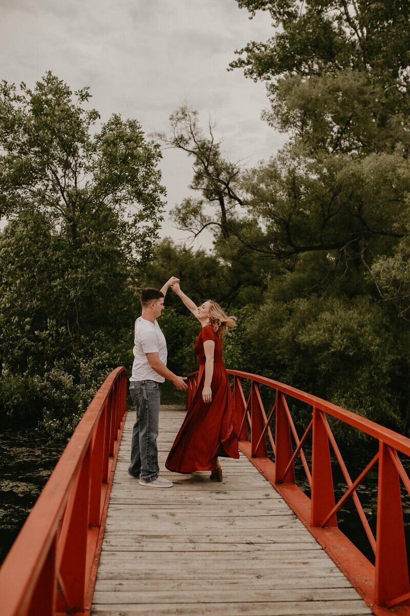 couple-dancing-on-red-bridge-romantic-session-iowa-storyteller-collective-photo-co