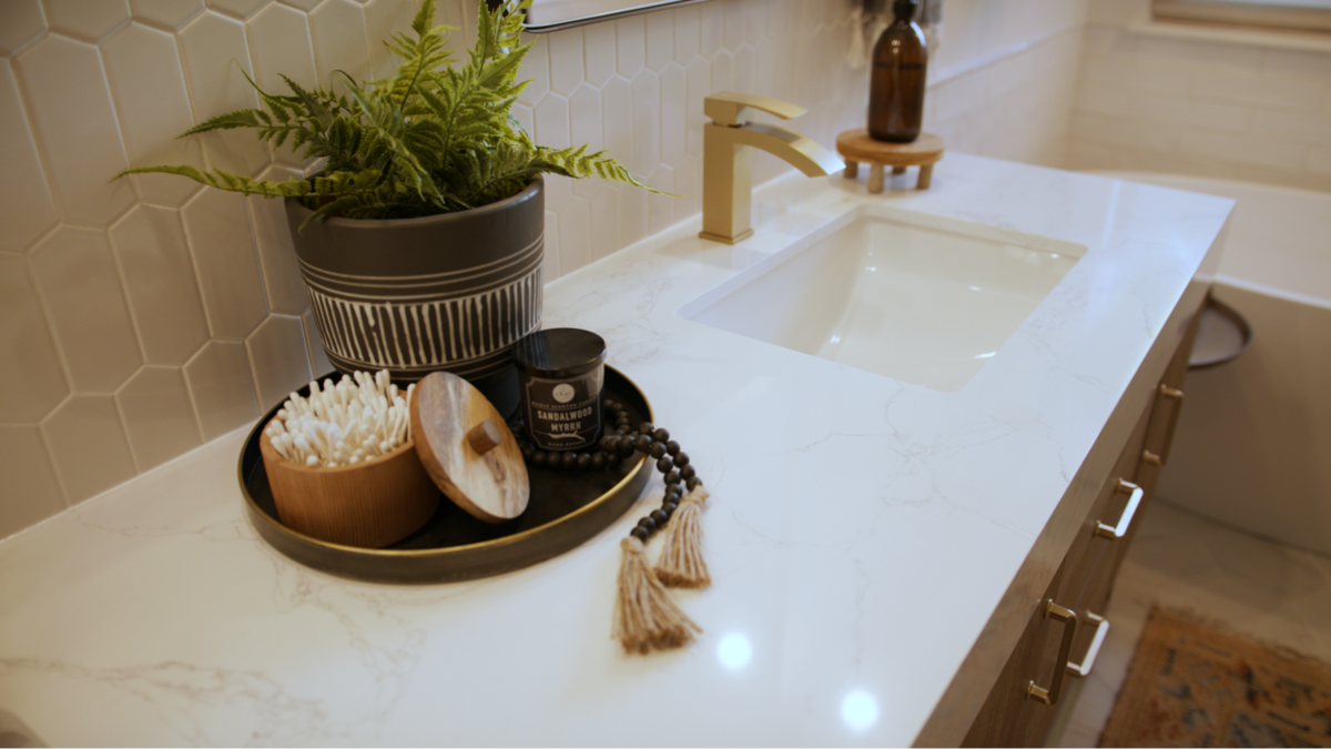 bathroom vanity with wooden cabinets and gold faucet