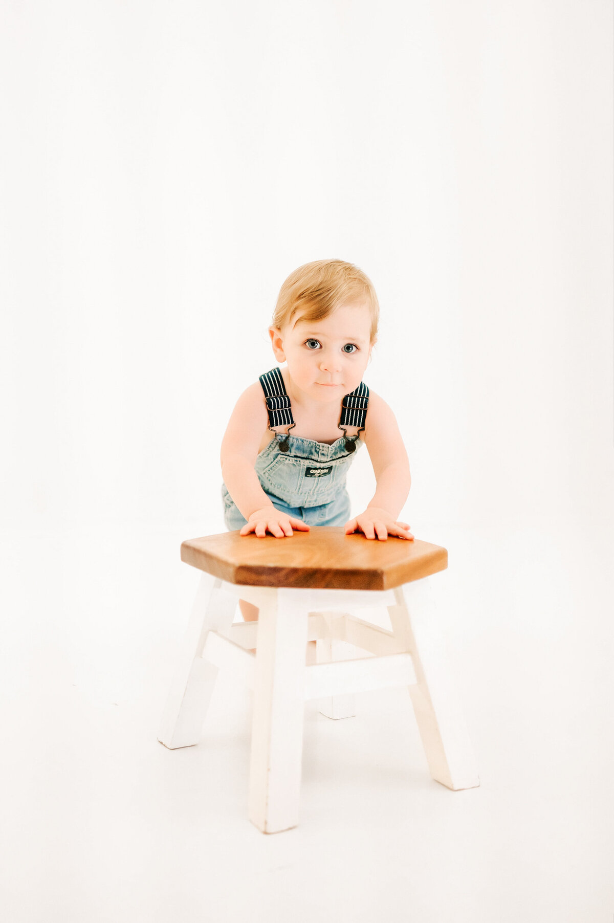 kid pushing stool grinning in Springfield MO kids and milestone photography studio