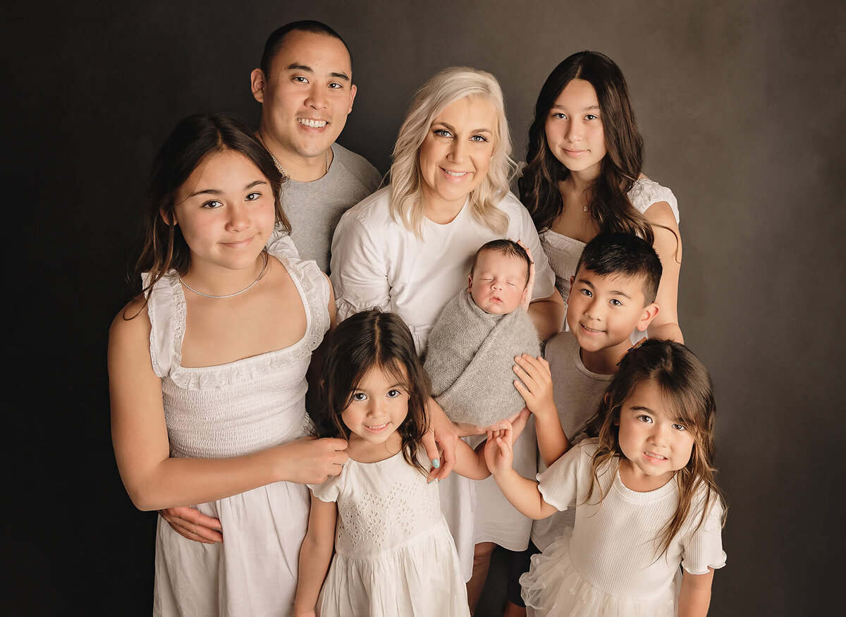 Toronto Newborn photoshoot of large family photographing their newborn boy at studio portrait session.