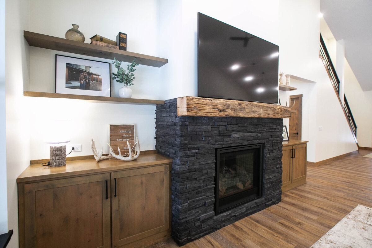Cozy living room in Elk River custom home with fireplace, built-ins, and large windows
