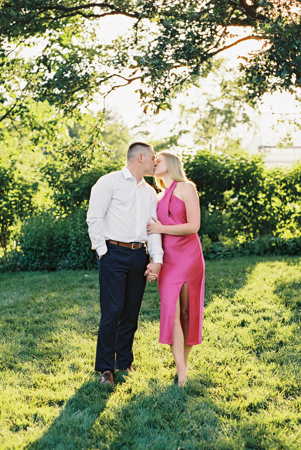 Engaged couple kisses surrounded by lush Columbus garden shot by Philadelphia photographer.