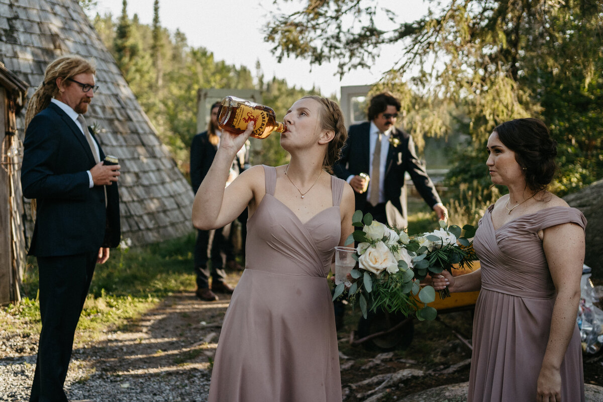 wedding party bridesmaid drinking bottle of Fireball