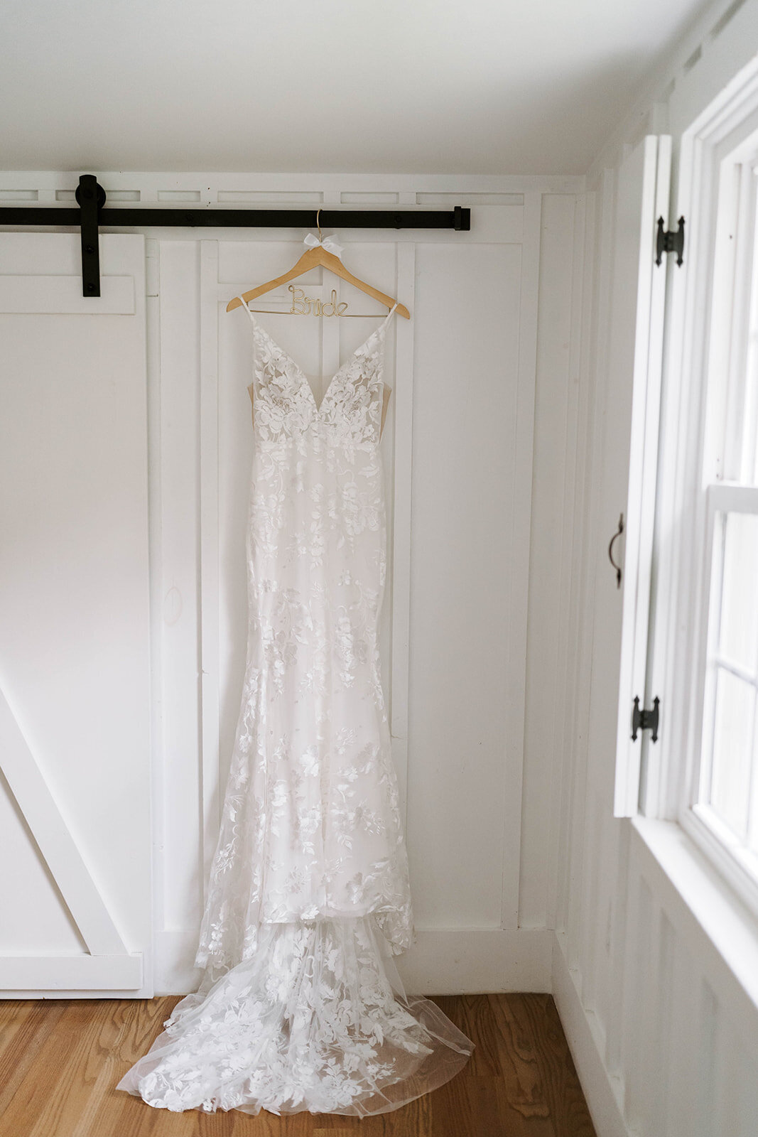 white wedding dress hanging in white painted newlywedsuit of farer cottage